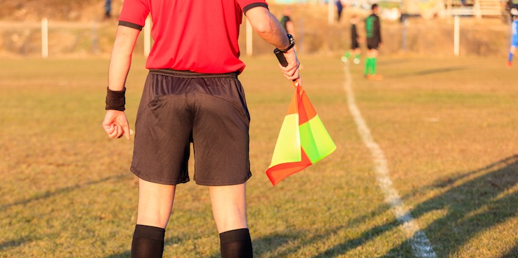 Image of linesman holding flag at soccer