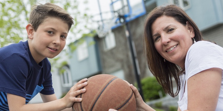 Image of mother and son holding basketball
