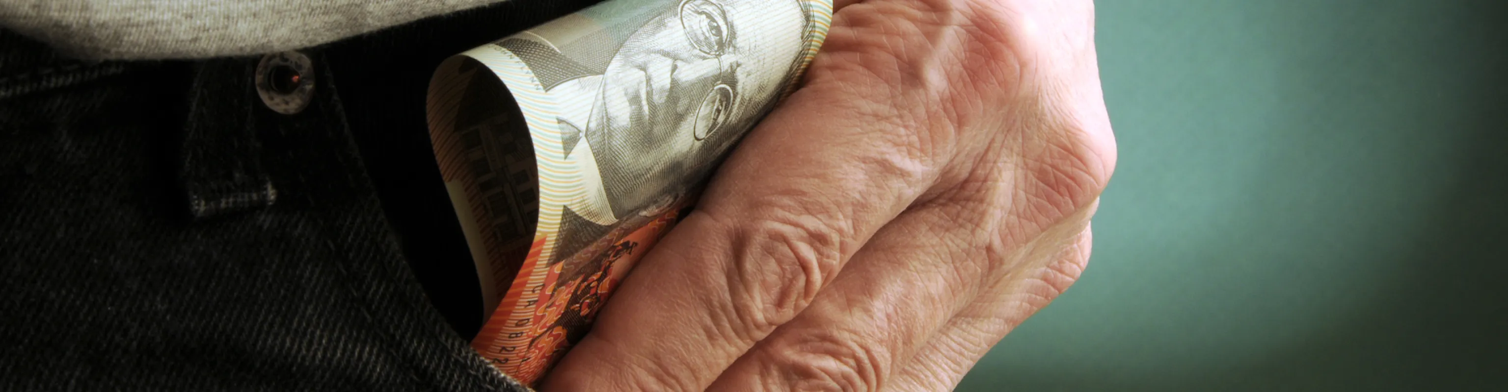 Image of male hand in pocket with money