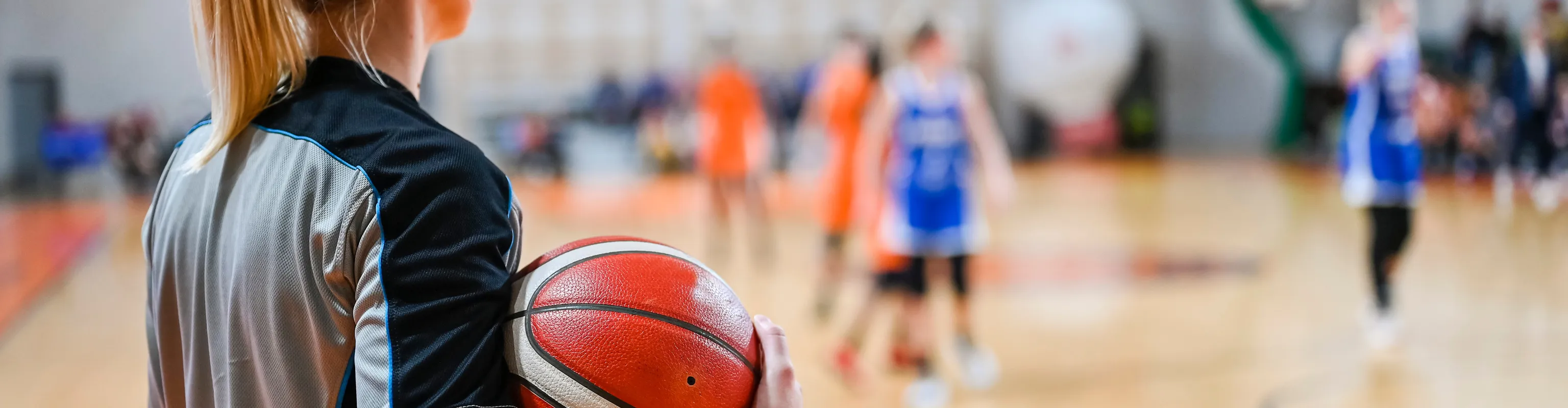 Basketball referee standing on side of court