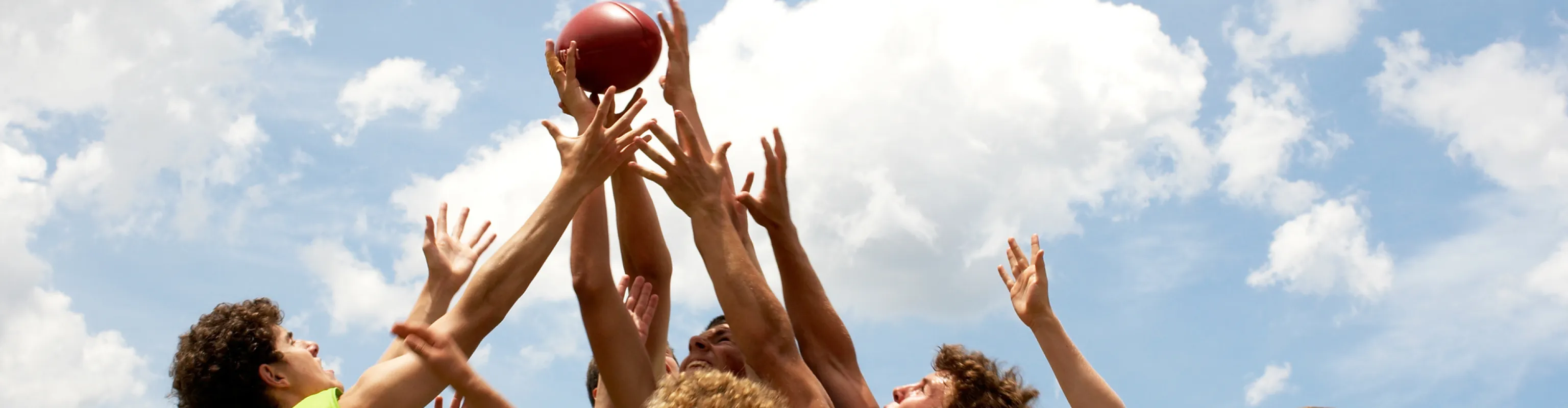 Ten boys going for a mark in a football game