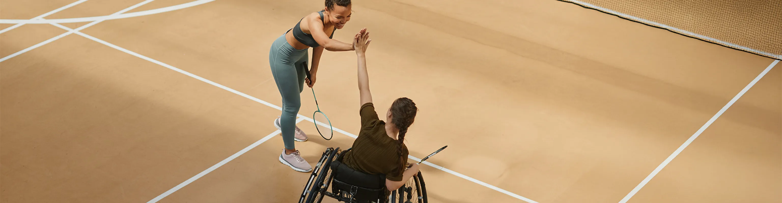 A coach and wheelchair athlete high 5 each other