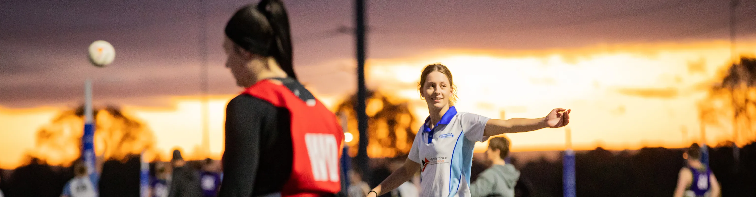 Young women playing netball in twilight