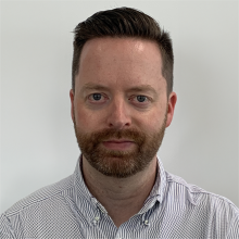 Man with fair skin and beard looking at camera
