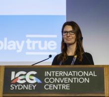 Woman standing behind a lecturn at a conference