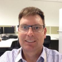 Photo of man with light brown hair and glasses smiling at camera