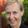 A portrait of Clare Hanlon. She has fair skin, blue eyes, blonde hair and is smiling.