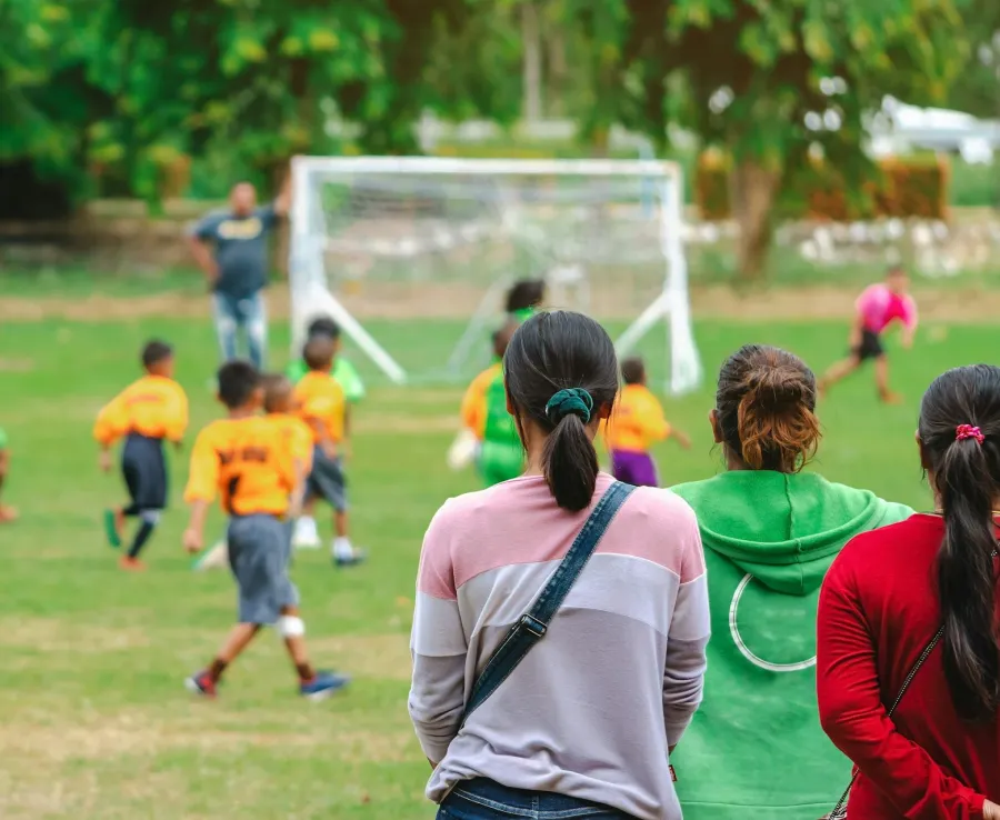 Parents watching kids playing football