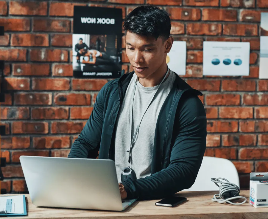 Man with dark hair using a laptop
