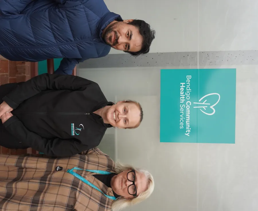 Three people standing under a logo