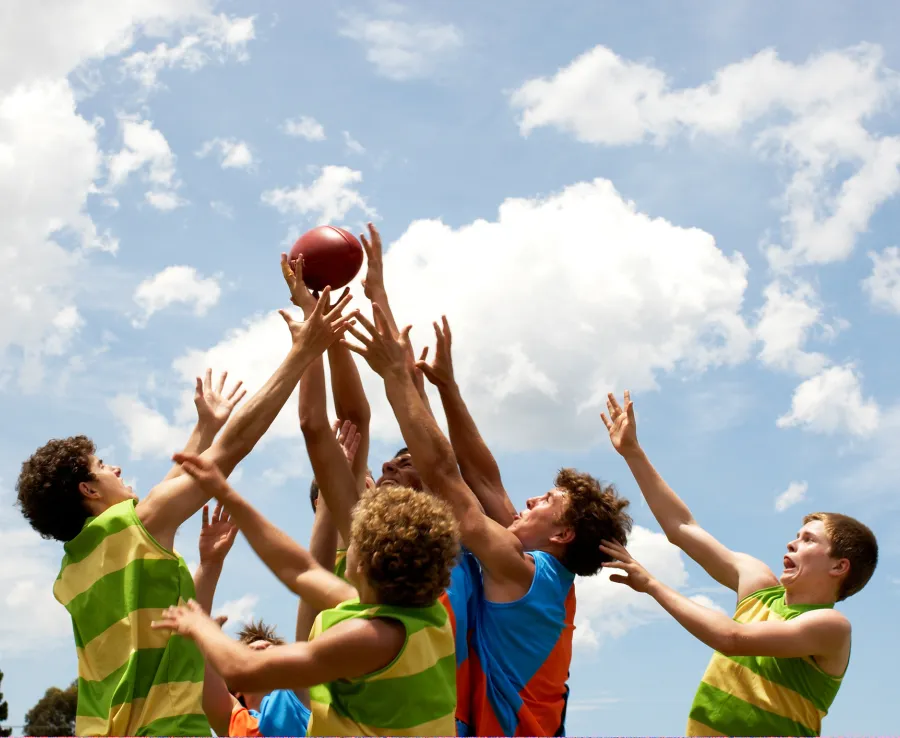 Ten boys going for a mark in a football game
