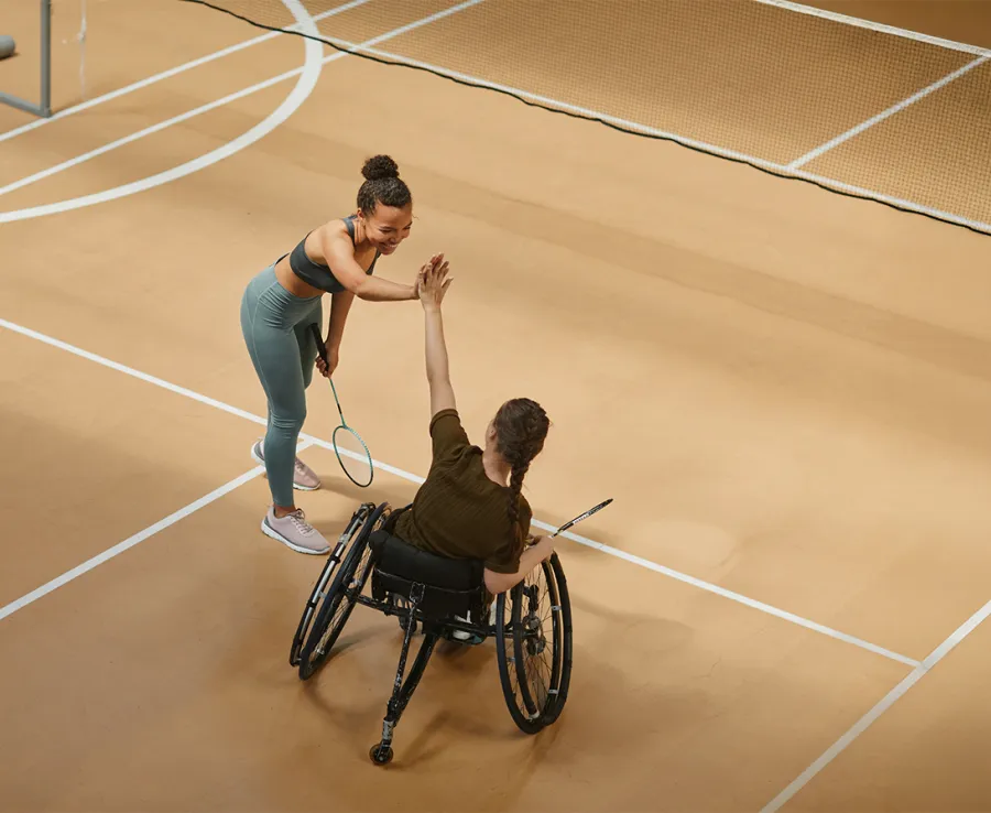A coach and wheelchair athlete high 5 each other