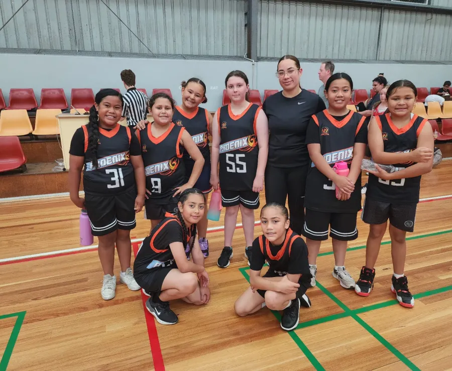 A Phoenix Basketball Club junior team poses with their coach