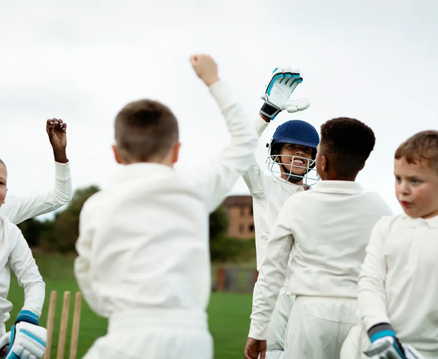Young boys celebrate a wicket in cricket