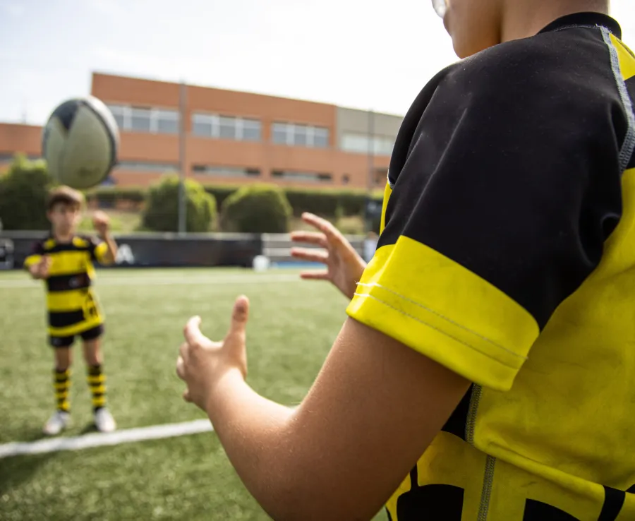 Junior rugby players practice their passing skills with the ball