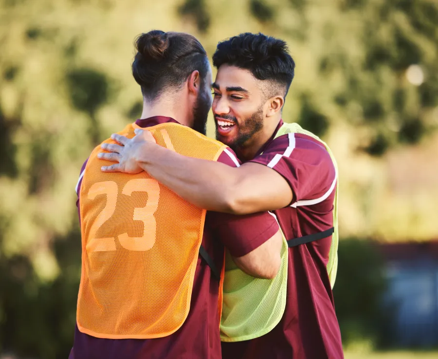 Two men share a hug at rugby training