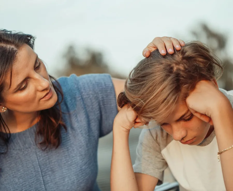 A mother comforts her son in a moment of distress