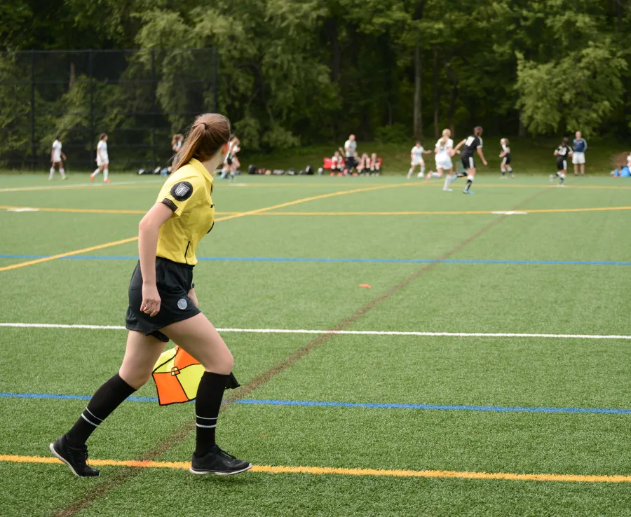 A young linesperson watches the play during a football match